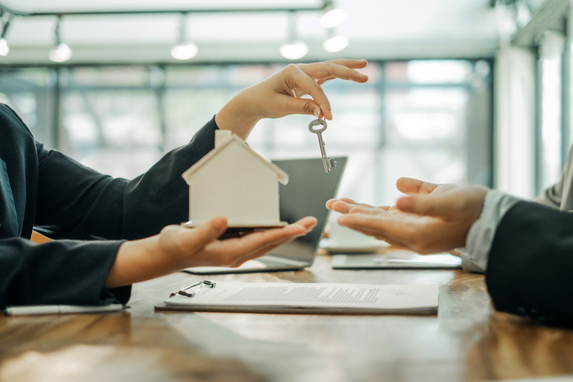 Real estate agents holding model house and keys for submit documents for customers to sign for a sale contract,real estate concept. Real estate agents holding model house and keys for submit documents for customers to sign for a sale contract,real estate concept.